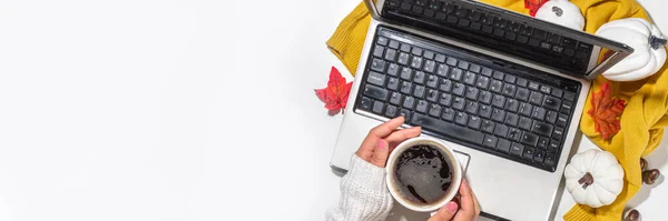 Cozy fall background with coffee cup, tablet notebook, ear-pods, white, orange pumpkins, autumn leaves decor on white home office table background. Autumn still life composition flatlay