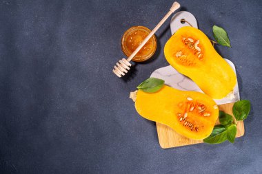 Bal kabakları değişik boyutlarda yemek pişirme arka planı, bitki ve baharatlı kabak türleri, zeytin yağı, bal, siyah mutfak masası arka planında Üst görünüm alanı 