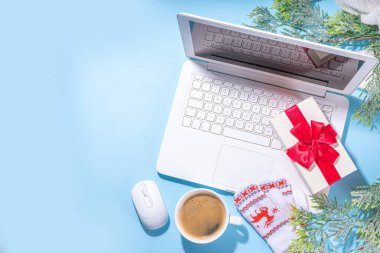 Kış ve Noel ofis çalışma alanı dizüstü bilgisayarı, not defteri, örgü eldivenler, kazak ya da ekose, Noel ağacı dalları, hediye kutusu, iş yerindeki düz konum üzerine dekorasyon üst görünüm alanı