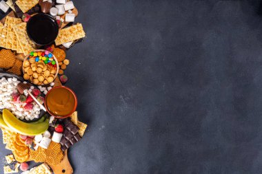 S 'mores ev yemeği ve malzemeler. Marshmallow, kraker, çikolata, meyve, çikolata, sos içeren açık büfe tabağı. Geleneksel sonbahar Amerikan çörekleri tatlısı 