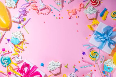 Mutlu yıllar tebrik kartı geçmişi. Renkli tatil aletleri olan düz yatak - doğum günü partisi şapkaları, şişirme makineleri, hediye kutuları, balonlar, buharlı mumlar, pembe arka plan fotokopi alanı
