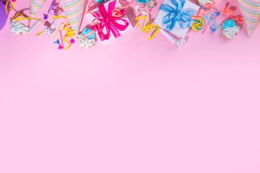 Mutlu yıllar tebrik kartı geçmişi. Renkli tatil aletleri olan düz yatak - doğum günü partisi şapkaları, şişirme makineleri, hediye kutuları, balonlar, buharlı mumlar, pembe arka plan fotokopi alanı