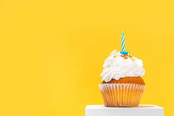 Birthday greeting card simple background. Homemade cupcake with candle for birthday holiday celebration, with gift box on background copy space