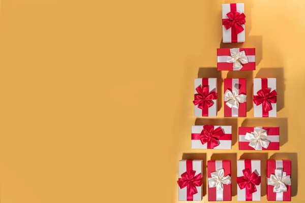 漂亮的圣诞红白色礼品盒 上面有彩带 背景是金色的 铺有彩带 — 图库照片