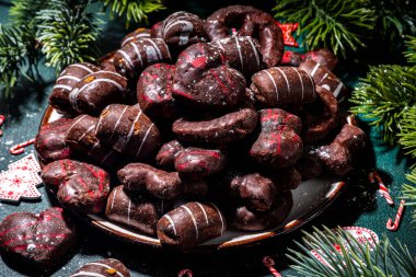 Noel lebkuchen kurabiyeleri, geleneksel Xmas çikolatalı zencefilli çörekler Noel süslemeleri, hediyeler, koyu yeşil masa üzerindeki Noel ağacı dalları fotokopi alanı