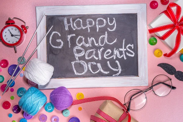 Happy Grandparents day greeting card background. Granny and grandpa's day celebration, with gift boxes, knitting threads, buttons, glasses, decor top view copy space
