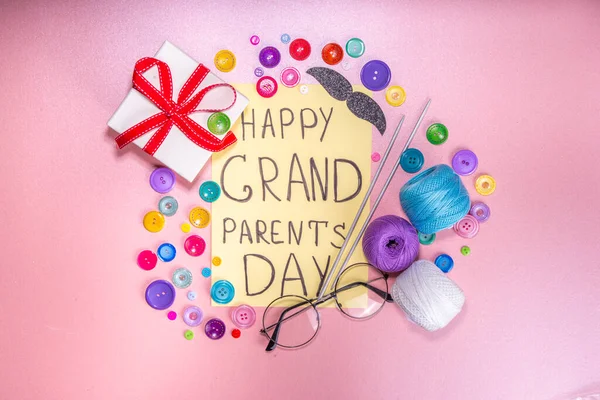 Happy Grandparents day greeting card background. Granny and grandpa\'s day celebration, with gift boxes, knitting threads, buttons, glasses, decor top view copy space