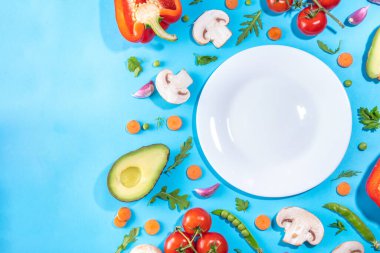 Çeşitli taze sebzeler. Çiğ organik sebzeler, salata malzemeleri canlı mavi arka planda parlak düz bir döşeme. Sağlıklı beslenme, vejetaryen vejetaryen yemek pişirme arka plan fotokopi alanı