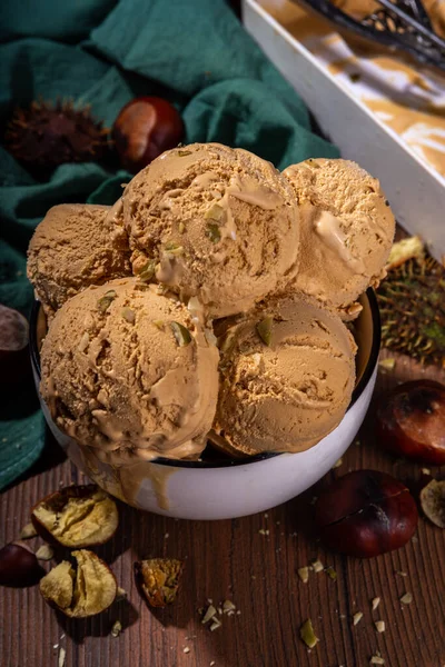 Baharatlı baharatlı dondurma, kavrulmuş kestane tadında, baharatlı, ahşap arka planda taze ve kavrulmuş kestane.