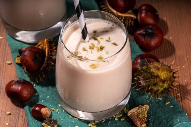 Kestane likörü. Baharatlı baharatlı kremalı içecek çırpılmış kestane, tarçın, baharat, ahşap kırsal arka planda fotokopi alanı.