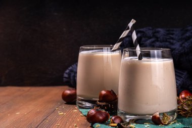 Kestane likörü. Baharatlı baharatlı kremalı içecek çırpılmış kestane, tarçın, baharat, ahşap kırsal arka planda fotokopi alanı.