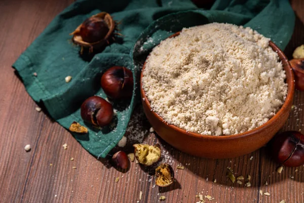 Kestane unu, alışılmadık vegan glütensiz un, taze ve kavrulmuş kestane ile ahşap zemin üzerinde
