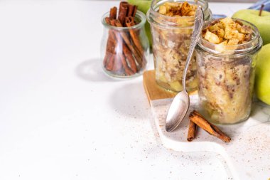 Cam kavanozda elmalı kek, mikrodalgada tarçınlı tarçınlı kek tarifi, beyaz arka planda fotokopi alanı.