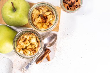 Cam kavanozda elmalı kek, mikrodalgada tarçınlı tarçınlı kek tarifi, beyaz arka planda fotokopi alanı.
