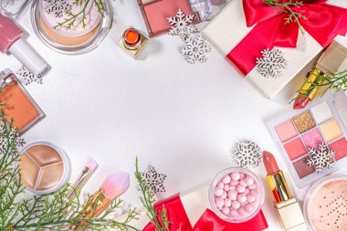 Kış ve Noel dekoratif makyaj malzemeleri, yapay kar taneleri, Noel ağacı dalları, hediye kutuları, güzellik aksesuarları. Noel ve Yeni Yıl kış kozmetik ürünleri satışı bembeyaz arka planda duruyordu