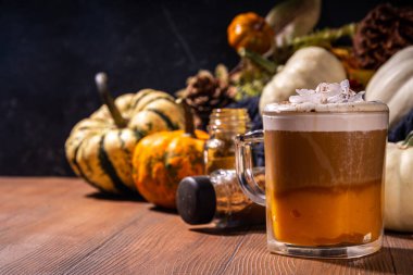 Lezzetli balkabağı aromalı latte, balkabağı kabağı kabağı, balkabağı turtası baharatları ve sonbahar dekorasyon alanı. Geleneksel sonbahar Şükran Günü tatili içkisi