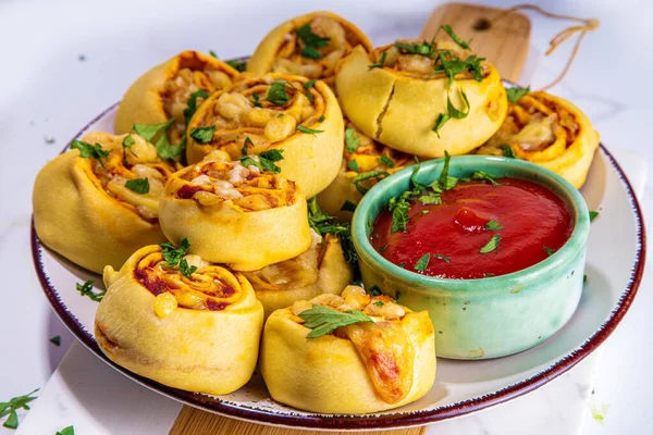 Homemade twisted Pizza rolls with tomato sauce, tomato, and cheese, trendy finger food eating pizza bites