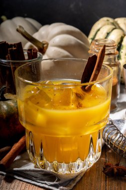  Ev yapımı ayyaş balkabağı tarçın kokteyli, taze balkabağı baharatı eski moda kokteyl, ahşap mutfak masası arka plan fotokopi alanı. 