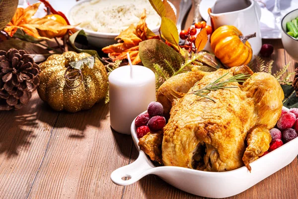 感謝祭の家族のディナーテーブルの設定プレート カトラリー グラス 伝統的な料理 焼き七面鳥や鶏 カボチャのパイ マッシュポテト 木製の背景 — ストック写真