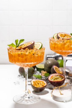 Tutkulu meyve martini kokteyli. Tatlı porno yıldızı alkollü içecek. Taze tutku meyvesi ve limon. Bar aletleri de yer kaplıyor.