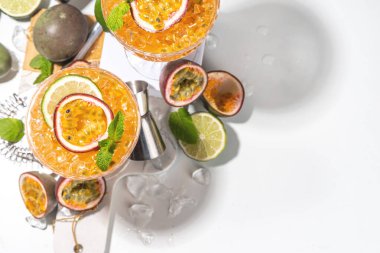 Tutkulu meyve martini kokteyli. Tatlı porno yıldızı alkollü içecek. Taze tutku meyvesi ve limon. Bar aletleri de yer kaplıyor.