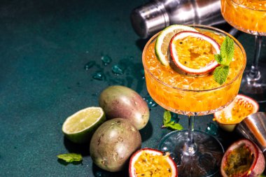 Tutkulu meyve martini kokteyli. Tatlı porno yıldızı alkollü içecek. Taze tutku meyvesi ve limon. Bar aletleri de yer kaplıyor.