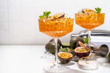 Tutkulu meyve martini kokteyli. Tatlı porno yıldızı alkollü içecek. Taze tutku meyvesi ve limon. Bar aletleri de yer kaplıyor.