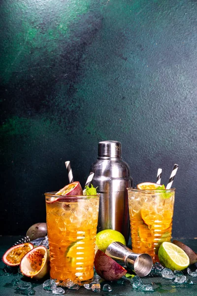 パッションフルーツ ライム ミントの甘いカラフルなトロピカルカクテル 暗い背景色の上に長い酒の情熱フルーツドリンクコピースペース — ストック写真
