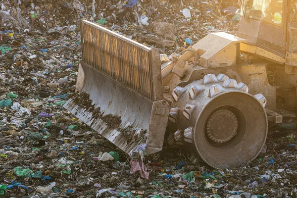 Excavator sorting metals for recycling at a recycling center, vertical image.