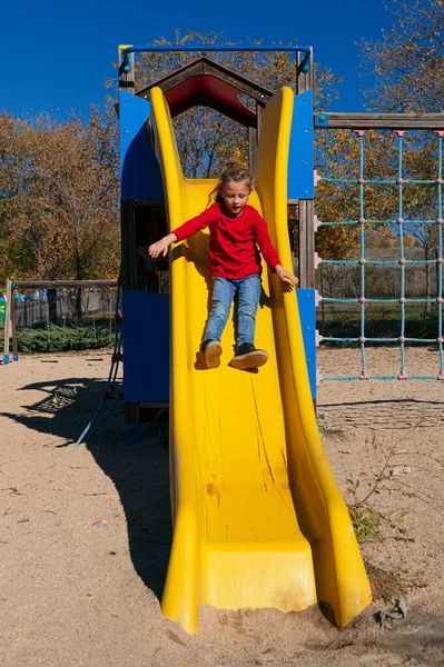 Little boy jumping on the slide ramp