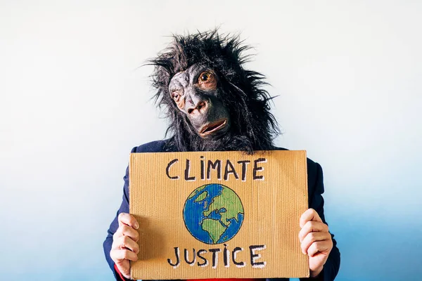 ゴリラのマスクの男は地球を救うと言うサインを示してる — ストック写真