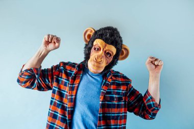 Maymun maskeli adam el kol hareketi yapıyor..