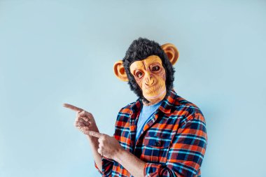 Maymun maskeli adam el kol hareketi yapıyor..