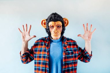 Maymun maskeli adam el kol hareketi yapıyor..