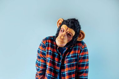 Maymun maskeli adam el kol hareketi yapıyor..