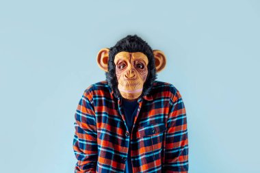 Maymun maskeli adam el kol hareketi yapıyor..