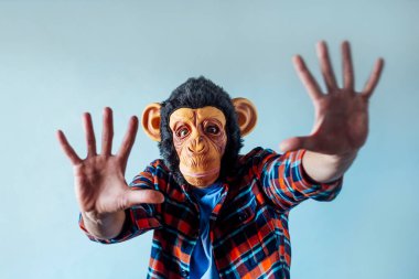 Maymun maskeli adam el kol hareketi yapıyor..