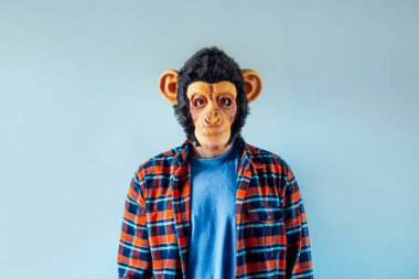 Maymun maskeli adam el kol hareketi yapıyor..