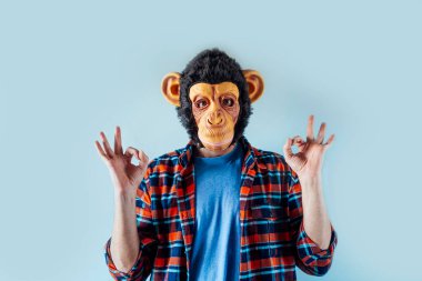 Maymun maskeli adam el kol hareketi yapıyor..