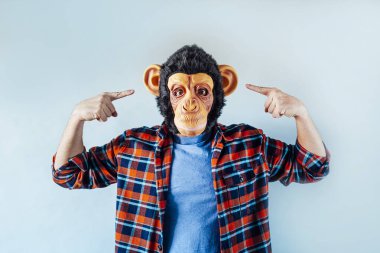 Maymun maskeli adam el kol hareketi yapıyor..