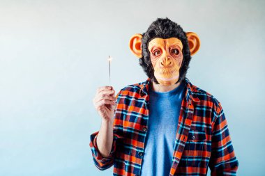 Maymun maskeli adam maytap yakıyor..