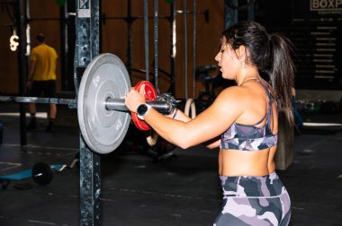 Dişi sporcu halteri eğitime hazırlıyor.