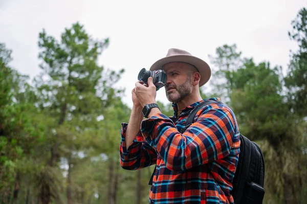 森の中のカメラを使って帽子を被った男の肖像画 — ストック写真