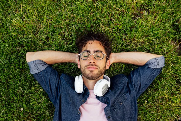 Retrato Aire Libre Guapo Joven Hipster Acostado Jardín Con Auriculares —  Fotos de Stock