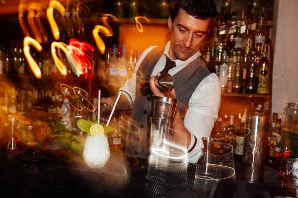 Barmen gece kulübünde kokteyl hazırlıyor..