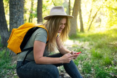 Şapkalı kadın dışarıda akıllı telefon kullanıyor..