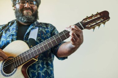 Mutlu sakallı adam akustik gitar çalıyor..