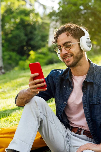 Outdoor Portrait Handsome Young Hipster Man Listening Music Headphones Mobile —  Fotos de Stock