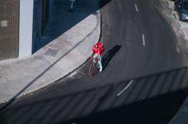 Şehirde yüksek hızda kuryeyle yemek getiren adam..