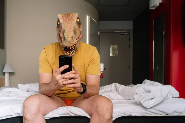 Homem Com Máscara Lagarto Usando Smartphone Uma Cama Hotel — Fotografia de Stock